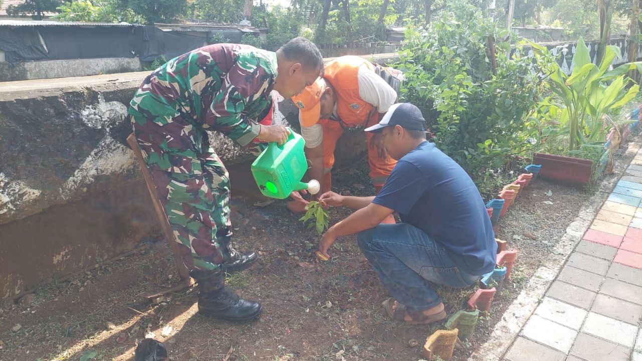 Babinsa Koramil 06/CP Laksanakan Pembersihan Lingkungan dan Perawatan Tanaman di Trotoar Jalan